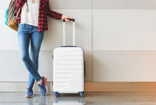 A imagem mostra uma pessoa com uma mala de viagem.